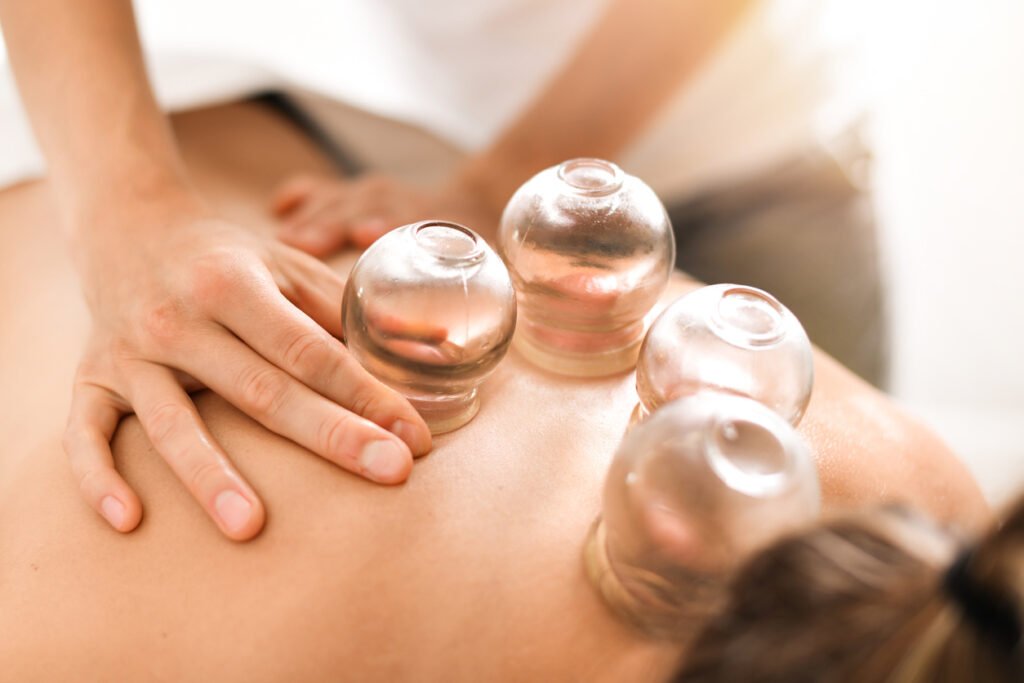Home detail of a woman therapist hands giving cupping treatment